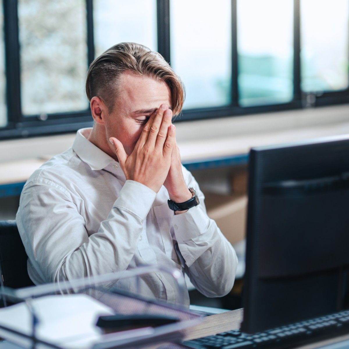 An older white man with light brown hair sits in front of his computer looking frustrated. He&#x27;s just found out his computer has a virus.