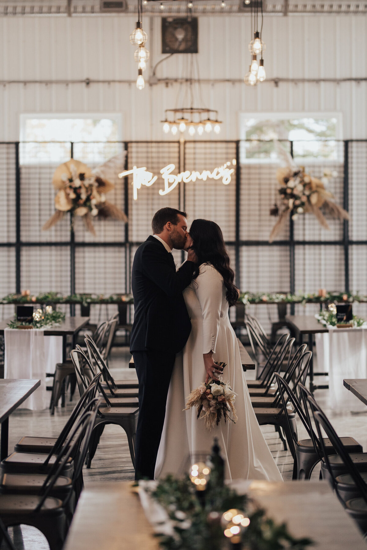 Bride and groom kissing at their 52 North Venue wedding, an industrial and unique wedding venue in Sylvan Lake, AB, featured on the Brontë Bride Vendor Guide.52 North Venue, an industrial and unique wedding venue in Sylvan Lake, AB, featured on the Brontë Bride Vendor Guide.