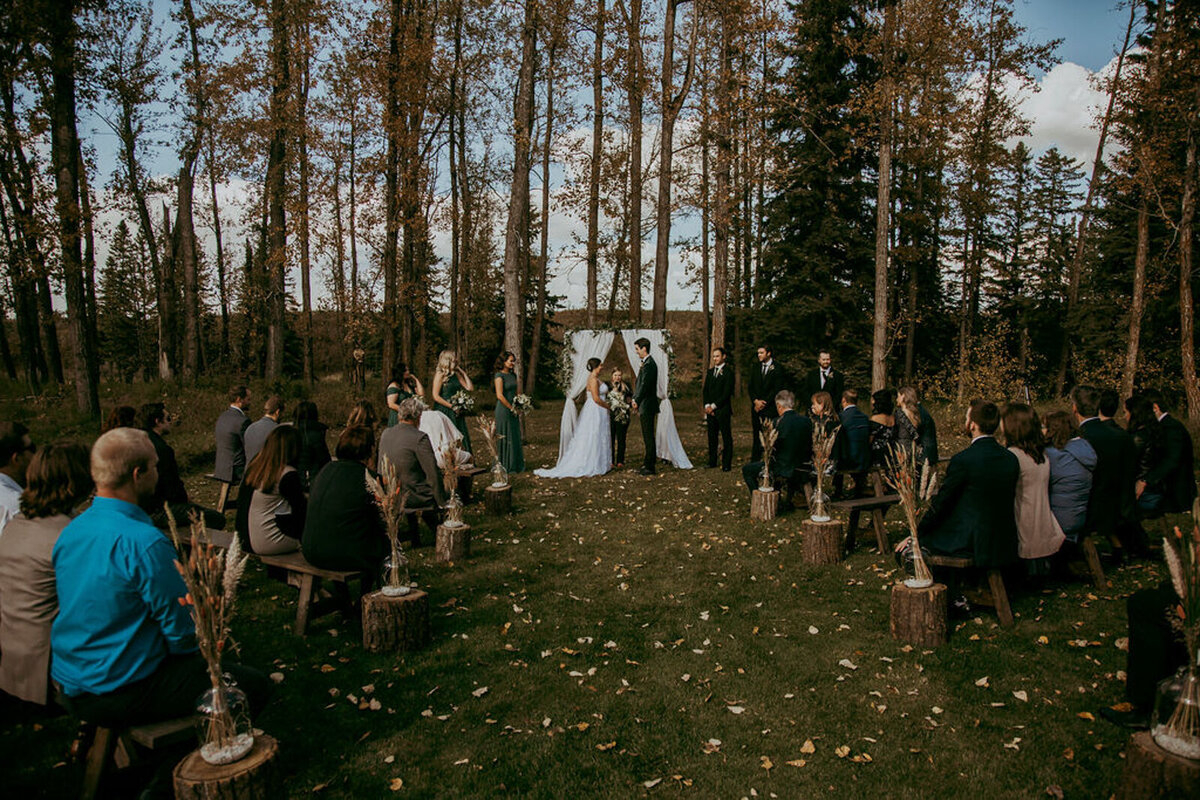 Outdoor fall wedding ceremony at 52 North Venue, an industrial and unique wedding venue in Sylvan Lake, AB, featured on the Brontë Bride Vendor Guide.52 North Venue, an industrial and unique wedding venue in Sylvan Lake, AB, featured on the Brontë Bride Vendor Guide.