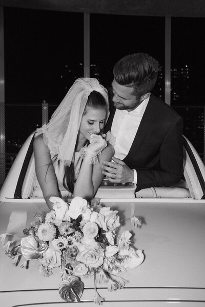 Trendy, modern bride and groom in the back of a vintage car.