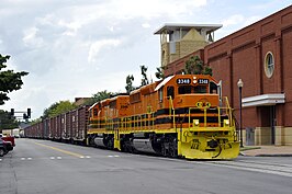 De Columbus & Chattahoochee goederentrein rijdt tegen het verkeer in door 9th Street, Columbus (GA), VS.