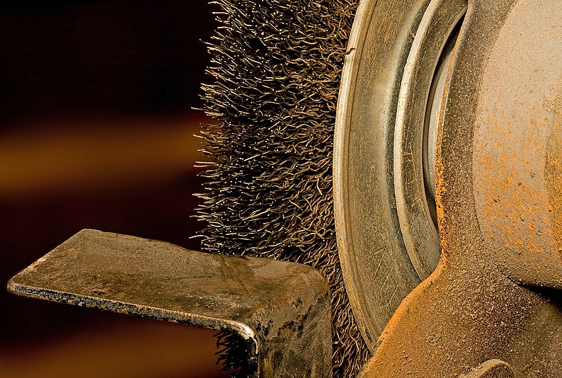 8in wire brush mounted to bench grinder (tool rest in foreground)