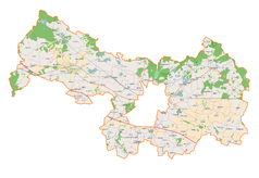 Mapa konturowa powiatu legnickiego, po prawej nieco u góry znajduje się ikonka zamku z wieżą z opisem „Zamek w Prochowicach”