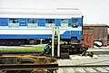 グロデコヴォ駅での台車交換作業。作業員が推す台車脇のコンクリート床に、取り替える中国形（ジャニー式）とロシア式SA3形の両方の連結器が置かれている。