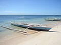 A small Philippine basnigan with the characteristic poles used for anchoring nets and holding gas-powered lamps for attracting fish