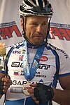 male cyclist standing on a winner's podium