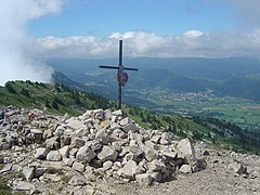 Village vu d'un point culminant avec une croix en premier plan.