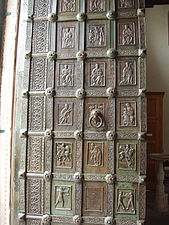 Puerta de la catedral de San Pantaleón de Ravello (1179), encargada por Sergio Muscettola; en el panel central de la tercera fila del batiente izquierdo de la puerta se encuentra una inscripción con la fecha incluida. Aquí se pueden ver figuras de arqueros y malabaristas que también se encuentran en la de Trani. Los marcos de partición de los paneles están ricamente decorados. Se encuentran escenas del Antiguo y del Nuevo Testamento.