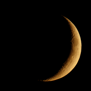 Ein zunehmender Mond drei Tage nach Neumond beim akronychischen Untergang am westlichen Abendhimmel drei Wochen vor der Tag-und-Nacht-Gleiche im Herbst. Die rötliche Färbung entstand genauso wie bei der untergehenden Sonne durch die Rayleigh-Streuung in der Erdatmosphäre.