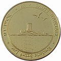 Médaille dorée représentant une tour sur une île.