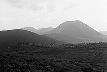 Photographie noir et blanc montrant un premier puy au premier plan et d'autres à l'arrière plan.