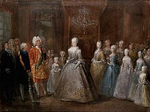 A throne room with a middle-aged lady in a silver dress standing in the middle, facin a man in a gilded red coat. Between them is a little girl in a light blue dress and a boy. Behind the lady stand five young girls, descending in height towards the edge of the canvas. Many courtiers are standing in the background.