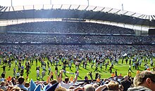 Photo des supporters envahissants le terrain du stade de Manchester City à la fin du match face à QPR, en 2012.