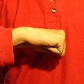 A, Fingers folded into a fist, thumb resting on the side of the other four fingers.