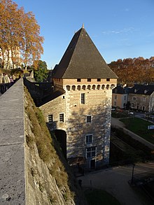 Photo d'une tour crénelée surmontée d'un toit en ardoise.