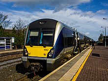 Passengers board train 4002, waiting at a platform at Holywood railway station.