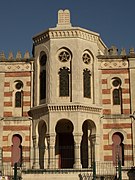 Bâtiment en pierre et en brique avec les tables de Loi le surplombant.