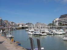 Vue en couleur d'un port de plaisance peuplé de voiliers.