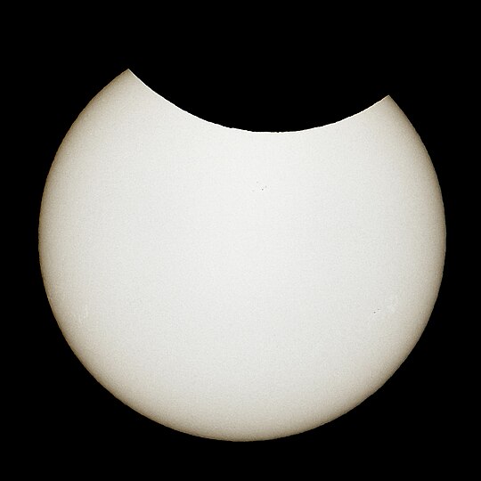 Partielle Sonnenfinsternis am 10. Juni 2021 in Berlin bei maximalem Bedeckungsgrad von 13,3 Prozent und einem entsprechenden Verfinsterungsgrad von 23,9 Prozent. Der Mond zog scheinbar von rechts nach links über die obere Kante der Sonnenscheibe; Vom ersten Kontakt zum Maximum der Bedeckung und dann wieder zum letzten Kontakt dauerte es jeweils zirka eine Stunde.