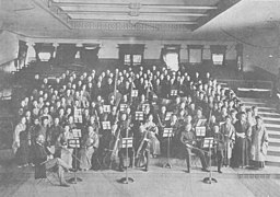 Photo d'un amphithéâtre d'université : un groupe d'étudiant prend la pose au premier rang.