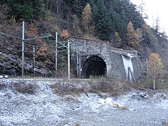 Photographie d'un tunnel gelé, avec des arbres persistants et une voie ferroviaire blanchie par le gel.