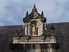 Photographie en couleur d'un détail sculpté sur la façade d'un bâtiment.