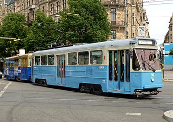 Vänster: Motorvagnen A1 76 och släpvagnen B19 846 vid spårvagnshållplatsen på Norrmalmstorg. Höger: Motorvagn A51 210 med släpvagnen B31C 618 "Cafévagnen" vid Nybroplan.