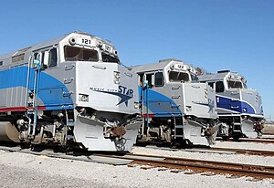 Three ex-Amtrak EMD F40PH locomotives in use by the WeGo Star lined up within the Lebanon, Tennessee yards. The third F40PH on the far right is painted in its original Pacific Surfliner scheme; all three locomotives have since been repainted.