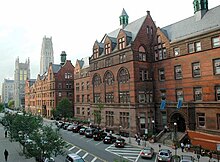 Image shows a brick building face with windows.