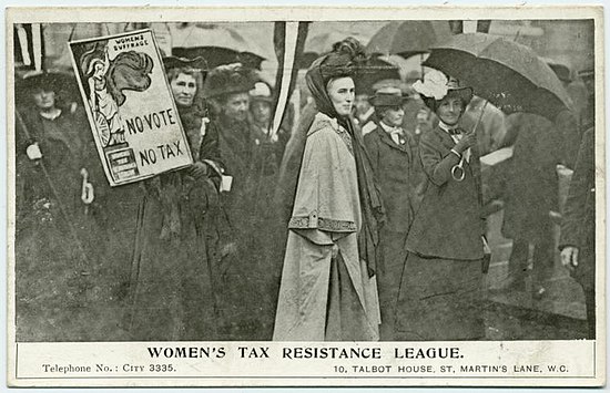 Clemence Housman est en gris au milieu de femmes habillées en sombre. À côté d'elle, une femme brandit une affiche représentant Minerve prête au combat, avec écrit « No Vote No Tax » et, sur son piédestal, Women's Tax Resistance League.