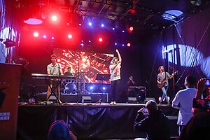 AJR performing "Bang!" in 2023. Ryan playing an electronic keyboard, Jack singing, and Adam playing a bass guitar. (pictured, left-to-right)