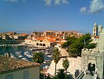 Marina in a city with churches and a fort.