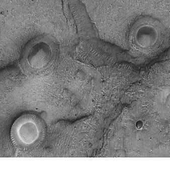 Craters with white centers in Mare Acidalium. Sand dunes are visible in low areas in image. Some of the features may be mud volcanoes. Picture taken by Mars Global Surveyor under the MOC Public Targeting Program.