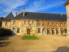 Bâtiment en pierre et en brique avec un toit pentu en ardoise.