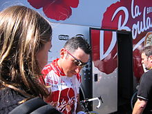 Photographie présentant Jérôme Pineau devant le bus de l'équipe pendant le Tour de France 2004.