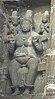 Stone sculpture of a broad woman seated on a throne, with two attendants