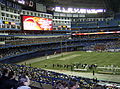 Concrete is exposed beyond the end zones and side lines because the field was shortened and narrowed from Canadian football to American football dimensions.