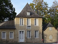 Photo d'une maison aux portes et fenêtres blanches et au toit en ardoise.