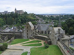 Photographie où l'on voit la cour du château ainsi qu'une église en hauteur sur l'arrière-plan.