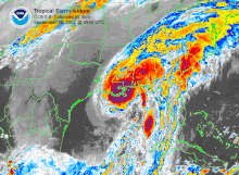 Colorized image of a hurricane with no eye, but clear banding features. Darker magenta shades indicate strong thunderstorms, and lighter, bluer shades indicate weaker convection.