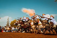 Fantasia exécutée à Aïn El Arbaa, dans la wilaya d'Aïn Témouchent, par un groupe de cavaliers photographiés au moment du tir de la salve de fusils.