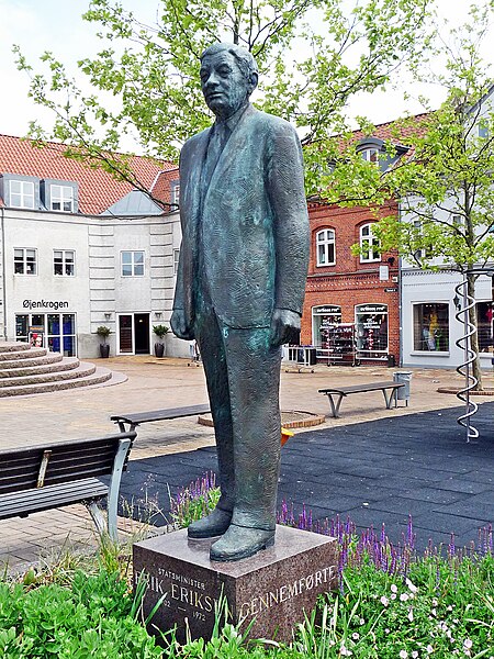 Statuen er udført i bronze. Den ståt på en granitsokkel i et kvadratisk blomsterbed. Den blev opsat i 1978 med støtte fra forskellige fonde og forestiller tidligere statsminister Erik Eriksen (1902-72). Han var statsminister 1050-53 og stod fadder til grundlovsændringen 5. juni 1953. Afsløringen af statuen var bl.a. med tale af Folketingets formand Karl Skytte og musik med Slesvigske Fodregiments musikkorps. Inskriptionen på soklens fire sider lyder: Statsminister Erik Eriksen 1902-1972/gennemførte/grundlovens/ændring 1953. Statuen blev flyttet til sin nuværende plads 1994.