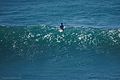 Surfer sitting on his board, thereby resting his back.