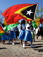 Kind in Atabae mit der Nationalflagge Osttimors