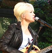 Cyndi Lauper playing a guitar.