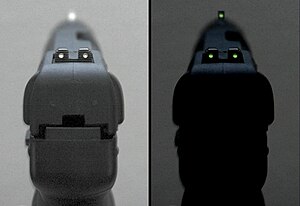 Photo of the tritium-illuminated fixed sights of the Five-seven USG pistol, in normal and dim lighting.