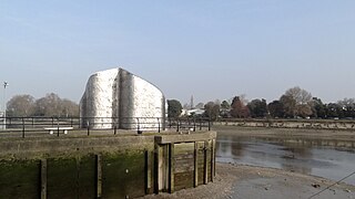 Sculpture à Ferry Wharf, Brentford, marquant l'entrée du Grand Union Canal depuis la Tamise à marée basse. Vue sur la Tamise jusqu'aux jardins de Kew. La sculpture s'appelle "Liquidity" et a été réalisée par Simon Packard en 2002.