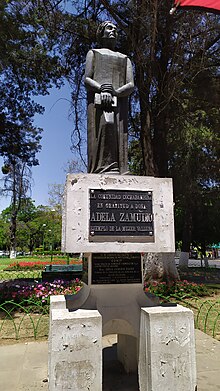 Statue of a kneeling woman holding a book.