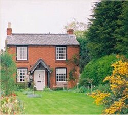 a brick country cottage with a large front garden