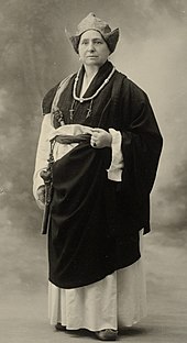 Photographie en noir et blanc d'une femme en costume traditionnel tibétain.